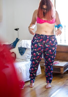 Plus-sized redhead on pink lingerie to get fully dressed next to the window