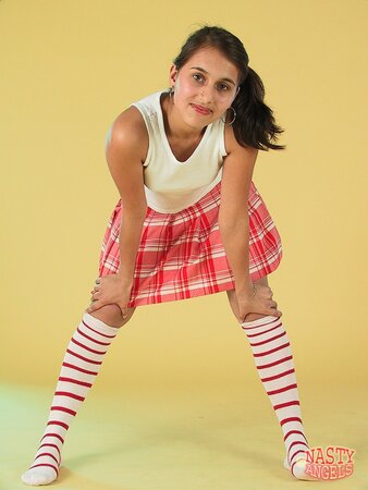 Teen strips down leaving only striped high socks on her sexy skinny legs