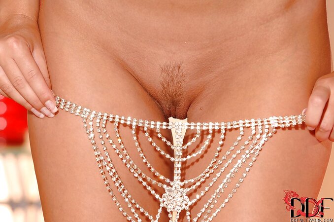 Attractive blonde young woman wears nothing but jewelry barely hiding her charms