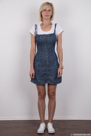 Porn model with big eyes reveals breasts and sits on stool crossing her legs