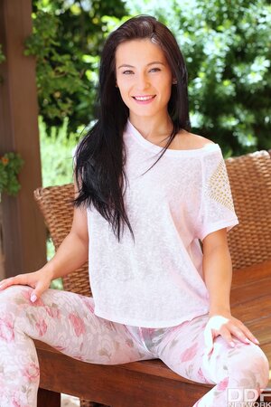 Slut gets on a wooden table on the terrace and masturbates trimmed pussy