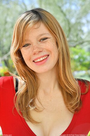 Pornographic girl with freckled face shows the color of panties pulling skirt up