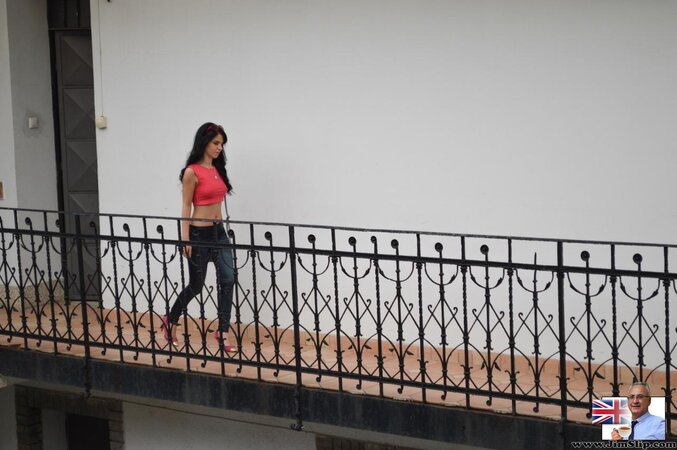 Babe with red sunglasses in hair wears blue jeans that she pulls down