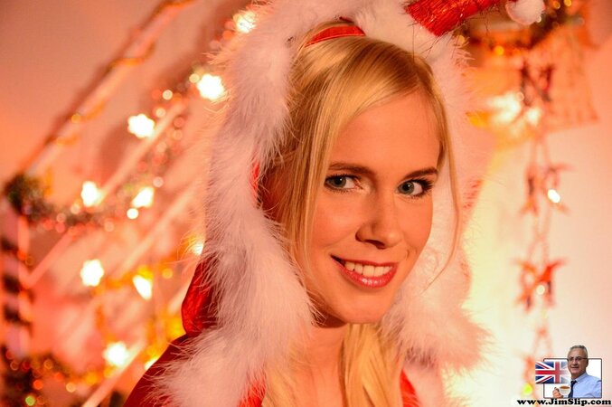 Blonde young woman in Snow Maiden's suit poses for fans on Christmas