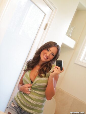 Chick takes her T-shirt and jean shorts exposing tattooed belly in front of mirror