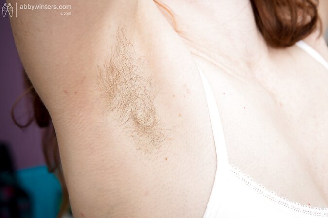 Girl with red hair and unshaved armpits does her morning exercises