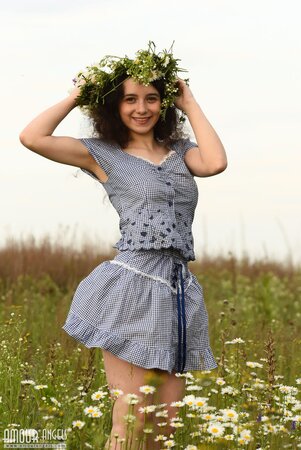 Girl made flower crown deserving herself a princess and exposing charms in a field