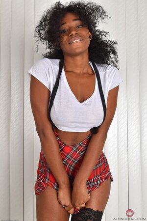 Curly chocolate girl in a checkered skirt has tits and slit to expose