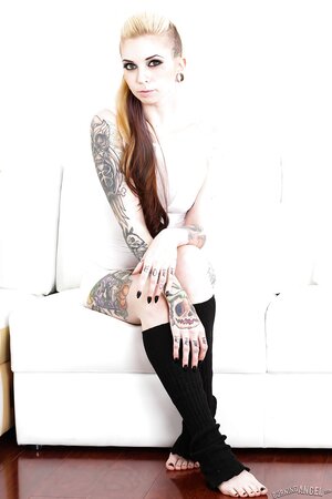 Female covered with tattoos puts black leg warmers on to underscore her sexuality