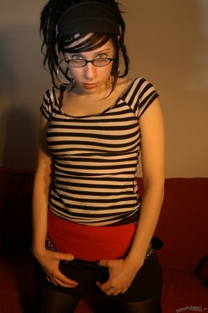 Babe with glasses and pierced nose playfully removes her clothes airing small tits