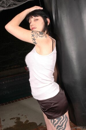 Tattooed female gets rid of outfit to hug a punching bag and press tits to it