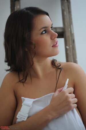 Chubby honey exposes her huge naturals while posing naked on the ladder