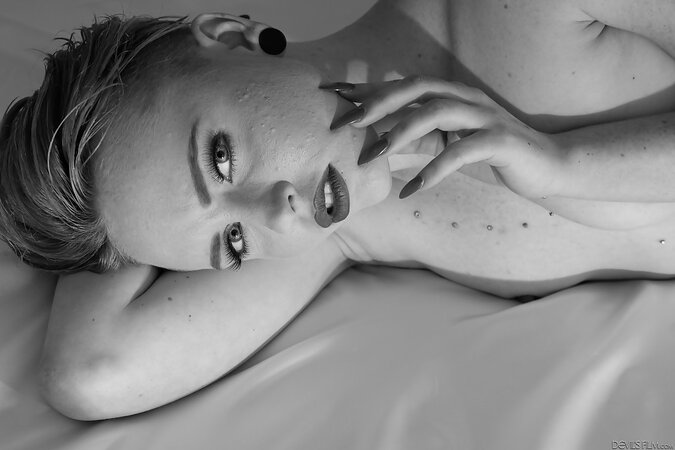 Short-haired slut with sexy piercing lies naked and spreads pussy for the cam