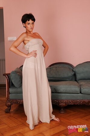 Enticing short-haired wench doffs long dress and teases with her slender curves