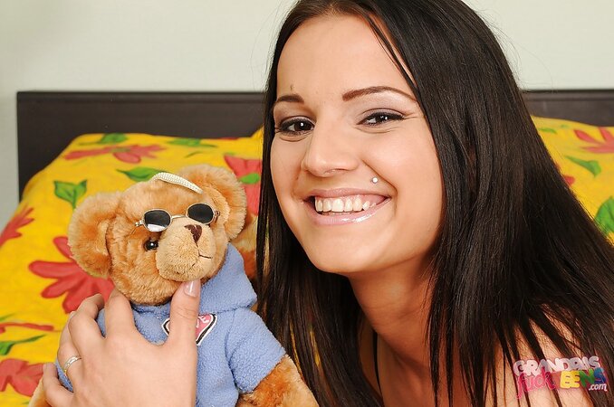 Playful black-haired bimbo plays with toys while modeling in bare nudity