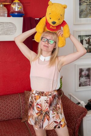 Geeky blonde with a hot body shows her hairy crotch on couch