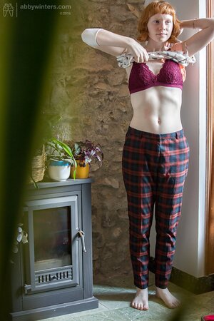 Redheaded cutie puts on her pants and looks very, very good