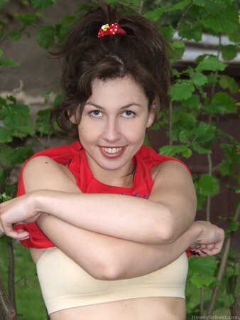 Young girl with a nice smile is outdoors and fingers herself