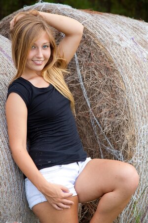 Breen is stripping down near a haystack on the grass