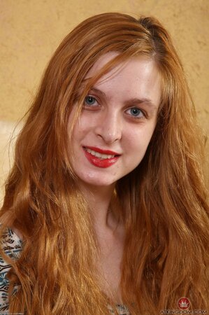 Redheaded girl with a tight body shows her big natural tits