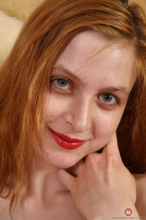 Redheaded girl with a tight body shows her big natural tits