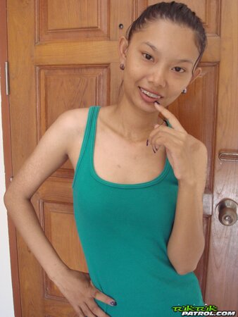 Skinny Asian girl is going to show nude body in a doorway