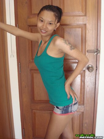 Skinny Asian girl is going to show nude body in a doorway