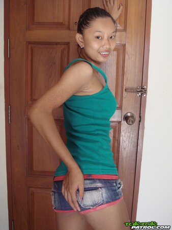 Skinny Asian girl is going to show nude body in a doorway