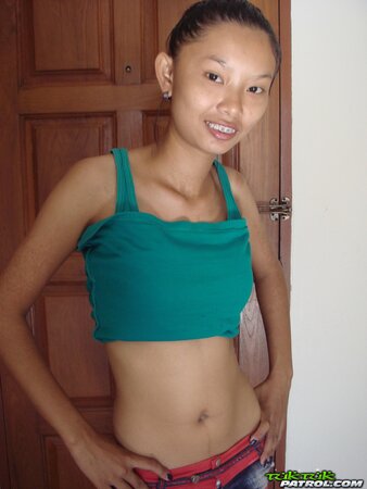 Skinny Asian girl is going to show nude body in a doorway