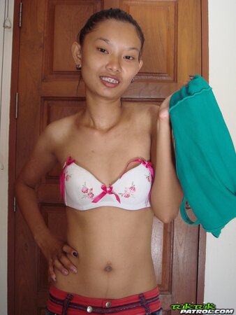 Skinny Asian girl is going to show nude body in a doorway