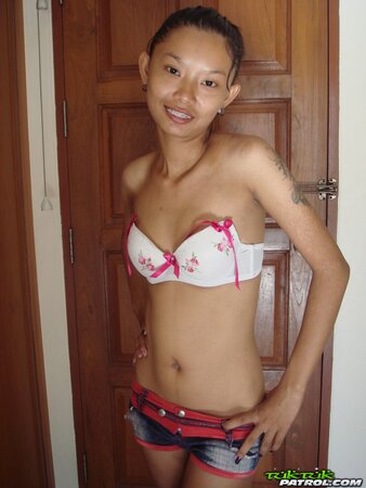Skinny Asian girl is going to show nude body in a doorway