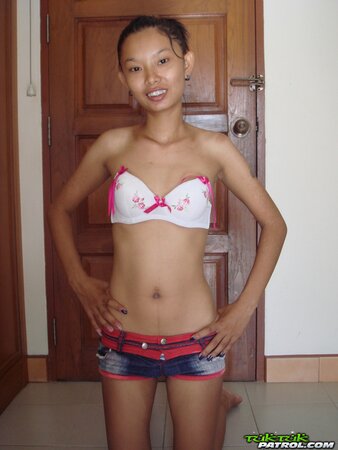Skinny Asian girl is going to show nude body in a doorway