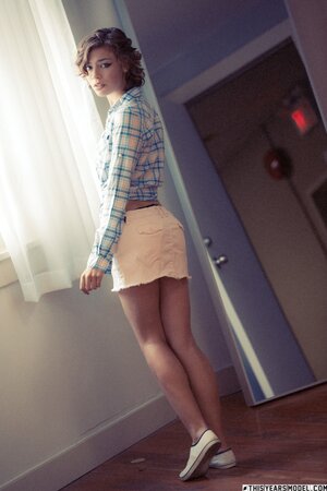 Short haired and curly brunette shows her nice breasts and more