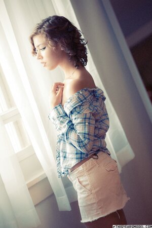 Short haired and curly brunette shows her nice breasts and more