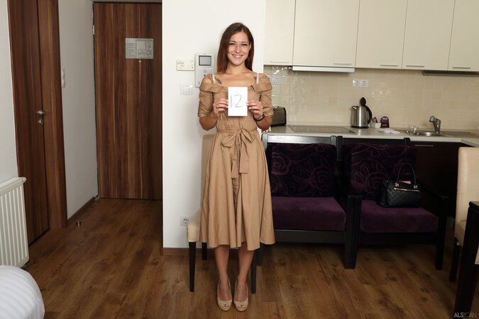 Mina K smiling as she removes her dress and flaunts her goods