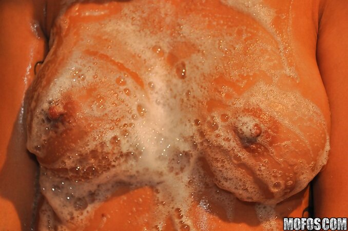 Playful brunette takes a foamy bath after which she starts masturbating