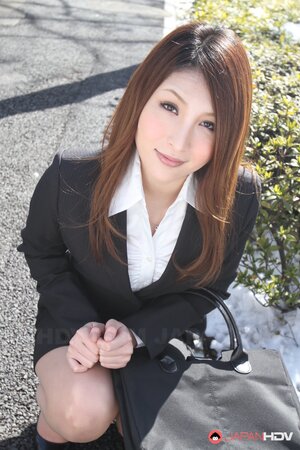 Redheaded Japanese girl in suit poses to show her beautiful face