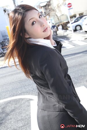 Redheaded Japanese girl in suit poses to show her beautiful face