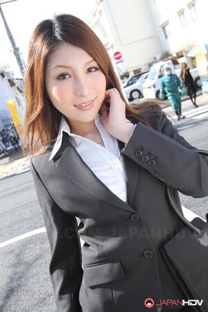 Redheaded Japanese girl in suit poses to show her beautiful face