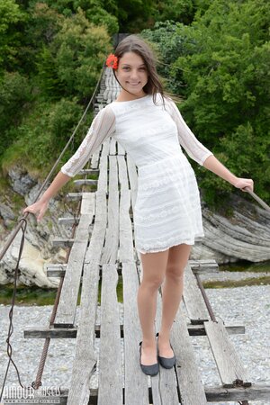 Frisky girl enjoys posing naked on top of a suspension bridge