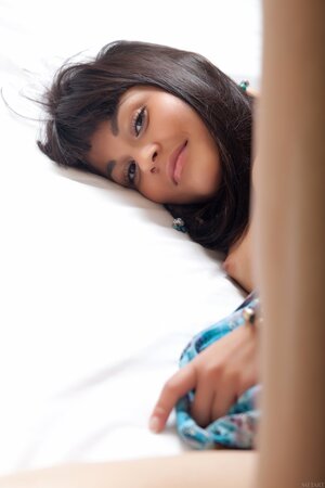 Cute teen Shereen A reveals her hairy pussy and poses on a bed