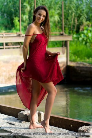 Alisa Amore disrobes to pose naked near a dam