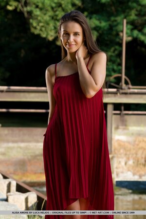 Alisa Amore disrobes to pose naked near a dam