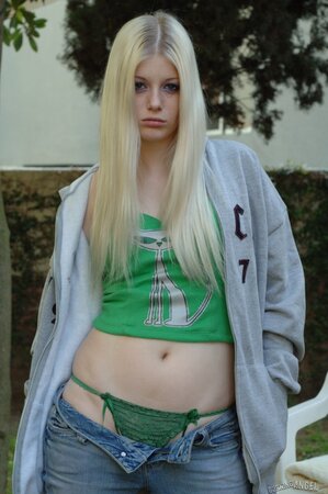 Blonde teen peels her green threads outdoors before cumming