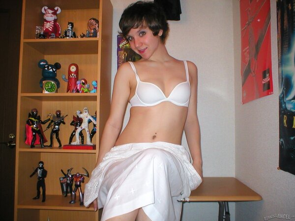 Schoolgirl with small boobs is posing for XXX pics in the bedroom