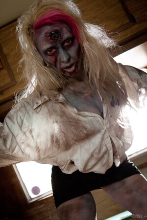 Horny zombie with big tits tears off her clothes in fetish pics