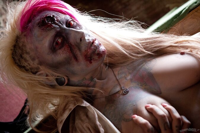 Horny zombie with big tits tears off her clothes in fetish pics