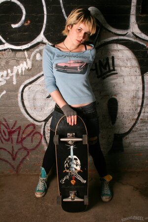 Young blonde skater girl with nice tits poses nude with her board