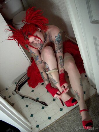 Fetish chick with flaming red hair spreads her chubby pussy wide in the bathroom