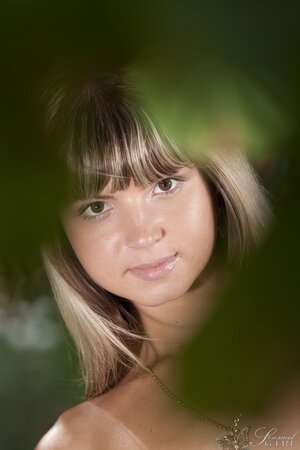 Lauren Lee on her knees naked in the grass showing her tiny kit